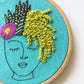 Close up of Zen Zoe Embroidery Kit.  Stitch detail of cactus in greens, white and pink.