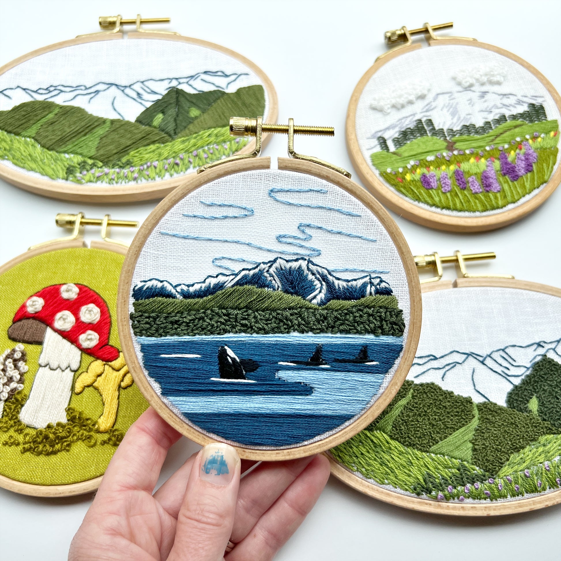 Rosanna Diggs Embroidery Pacific Northwest Collection includes: Fungi, Hurricane Ridge, Mount Rainier and Orcas in the Sound.