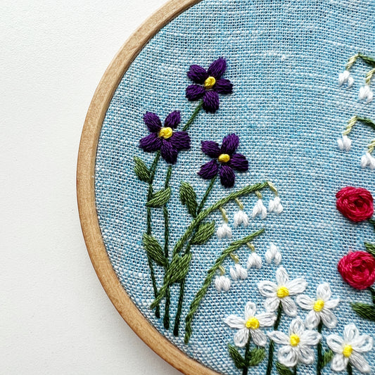 Close up of Family Flower Garden Kit.  Stitch detail of selected flowers on white linen.