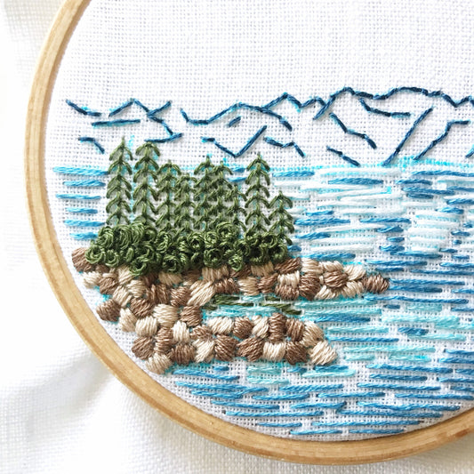 Lake Tahoe is a great pattern to DIY your own modern embroidery hoop art. This 12 page pdf details everything you need to know to stitch this beautiful embroidery.  Mountains in the background with trees, rocks and lake in front.